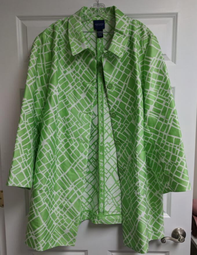 green and white raincoat hanging on door